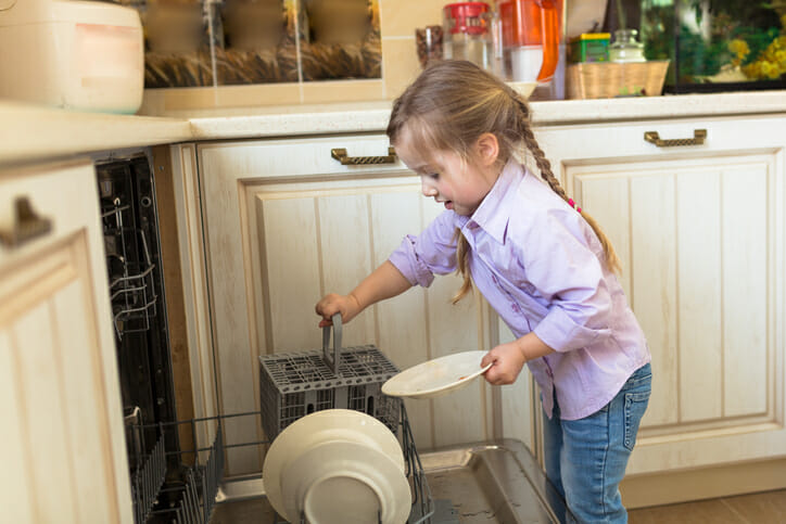a young girl emptying the dishwasher